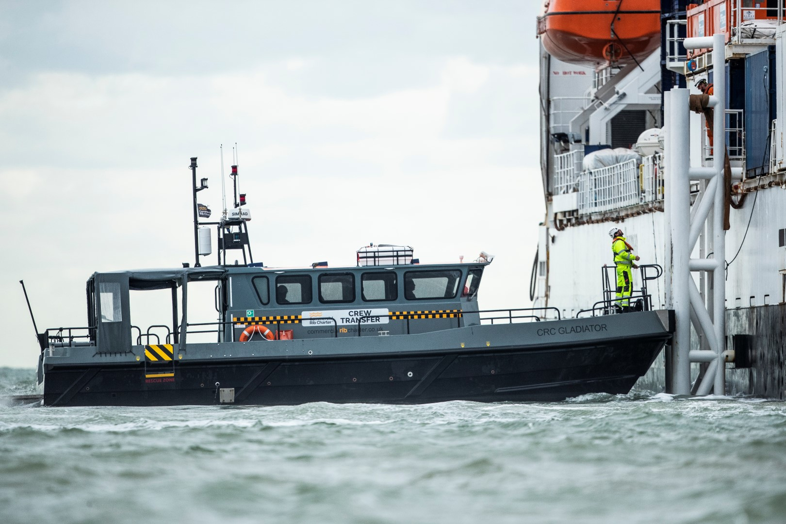 Commercial Rib Charter crew transfer vessel alongside an offshore support vessel during personnel transfer operations.