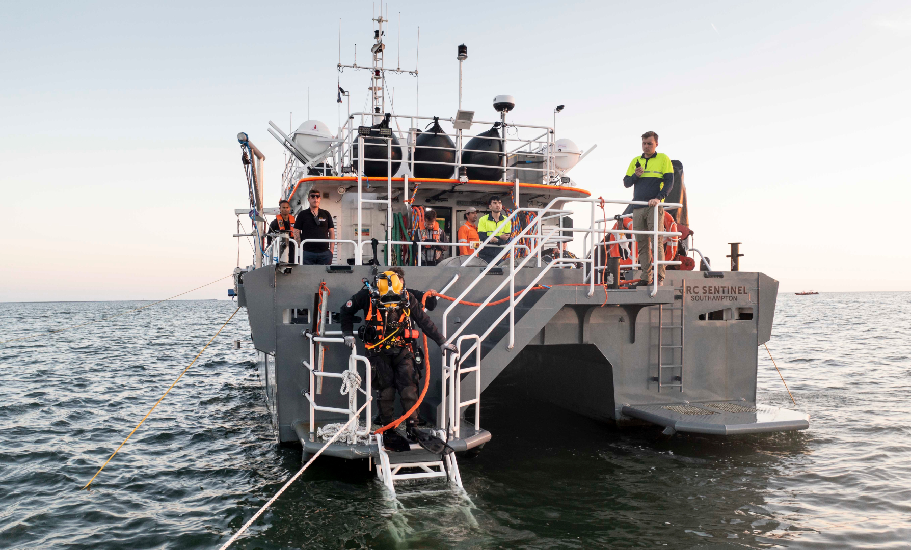 Commercial diver entering the water from CRC Sentinel dive support vessel during offshore subsea operations.