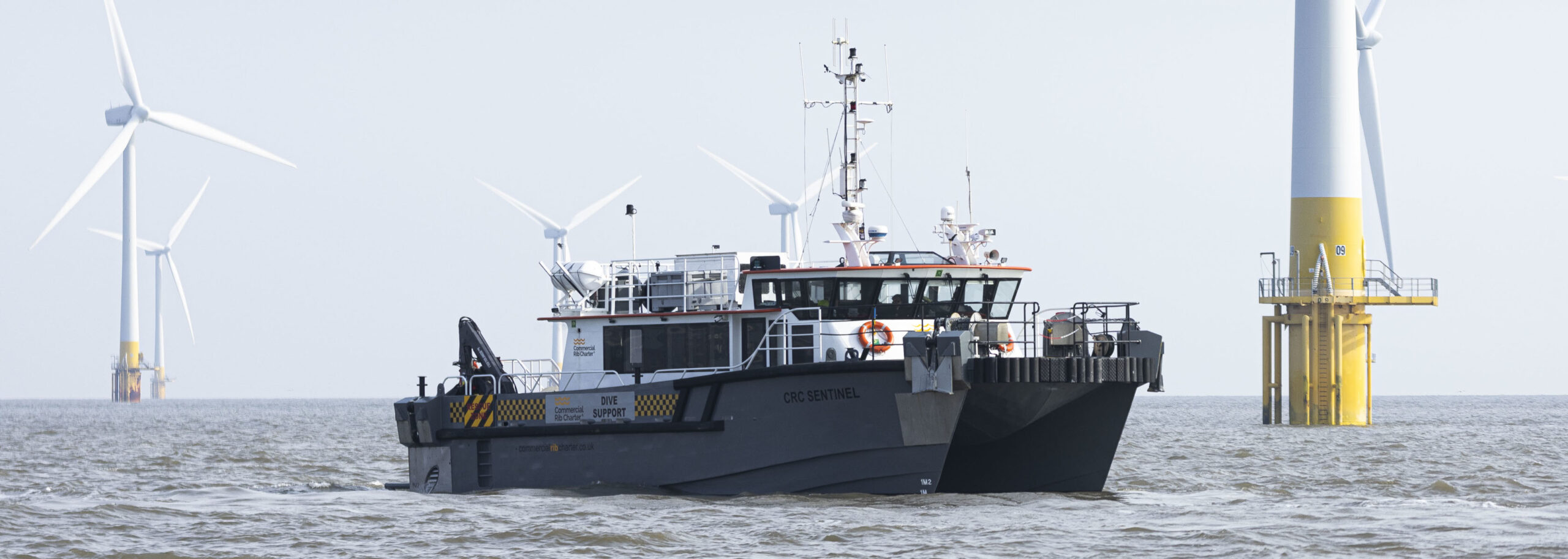Commercial RIB dive support vessel operating within offshore wind farm, providing marine safety, crew support and exclusion zone management around wind turbine foundations in UK waters.