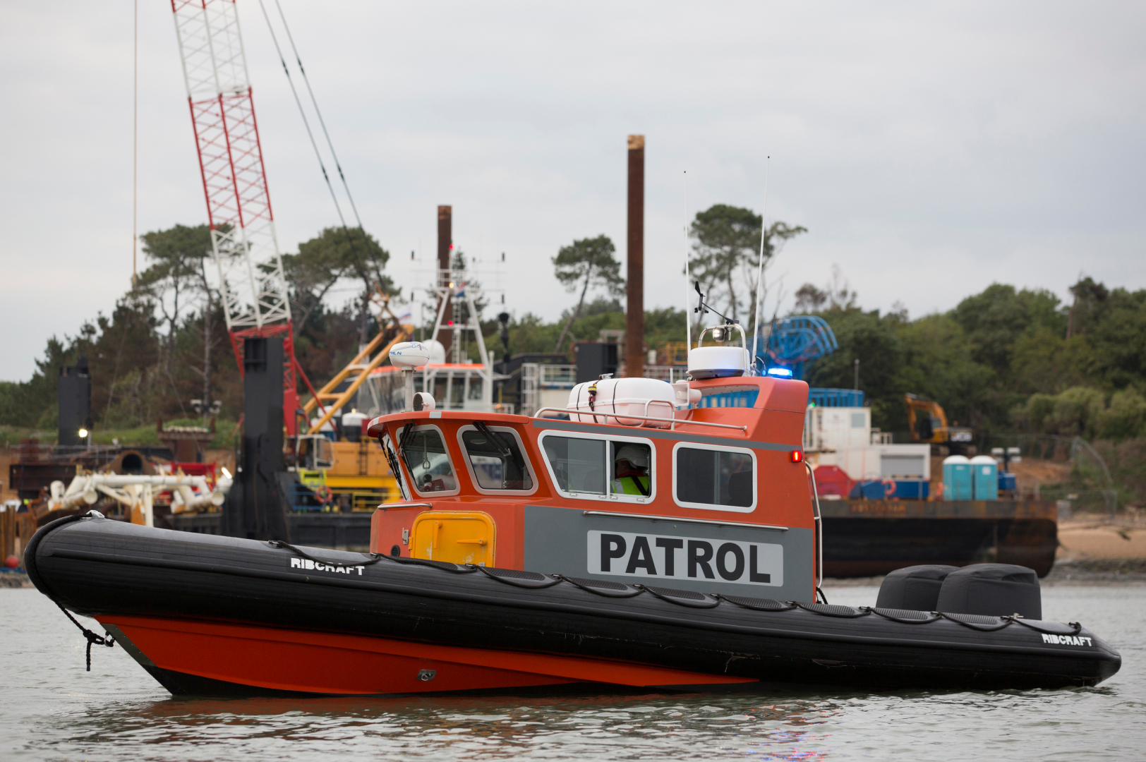 Commercial RIB patrol vessel operating alongside marine construction works, providing safety patrol and site support in UK coastal waters.