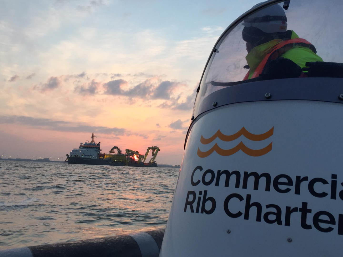 Commercial RIB charter vessel operating at dusk during offshore marine works, supporting marine construction and crew transfer operations in UK coastal waters.